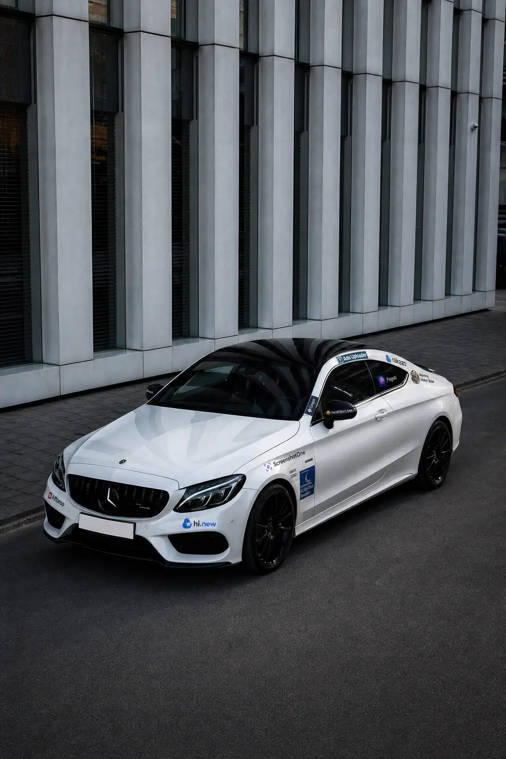 The white Mercedes-AMG coupe wearing sponsor logos